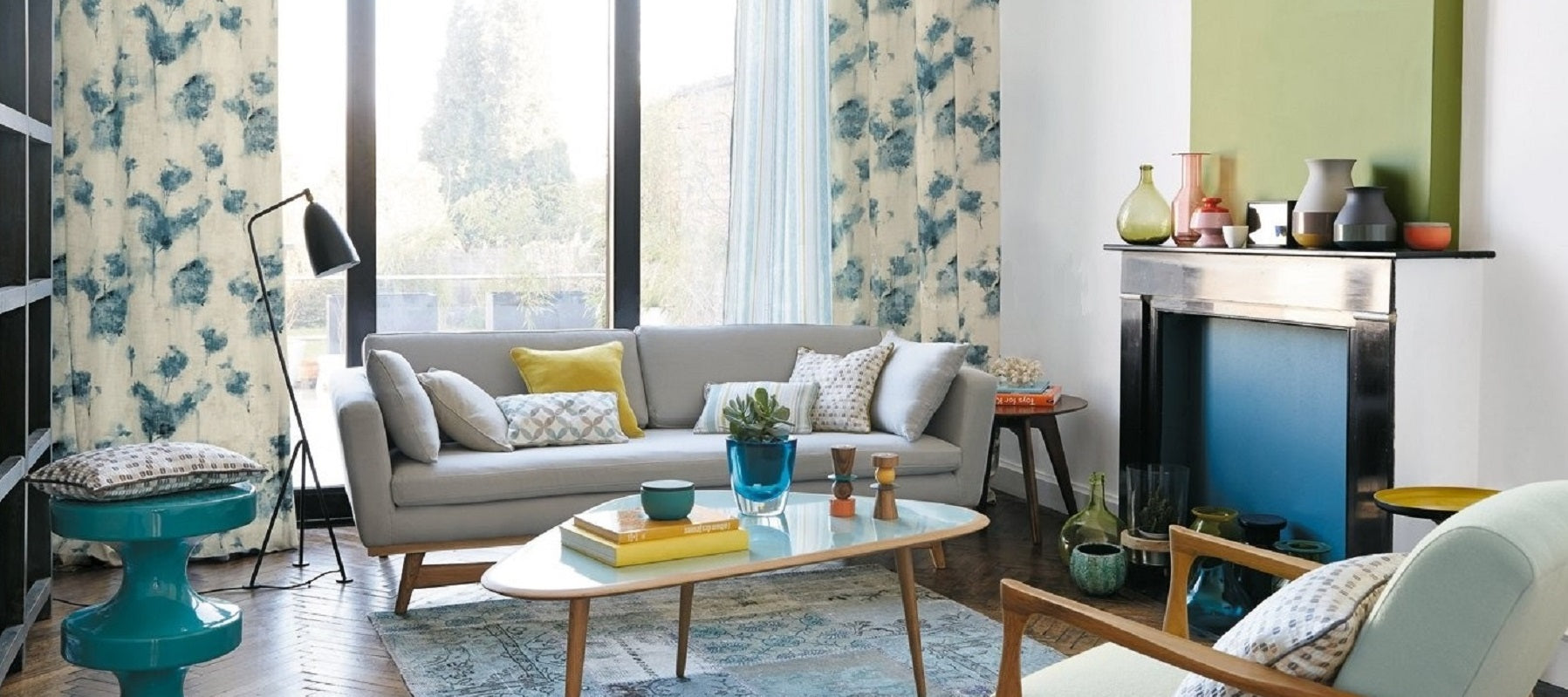 living room with light gray upholstery fabric covered sofas and cushions blue patterned curtain fabric