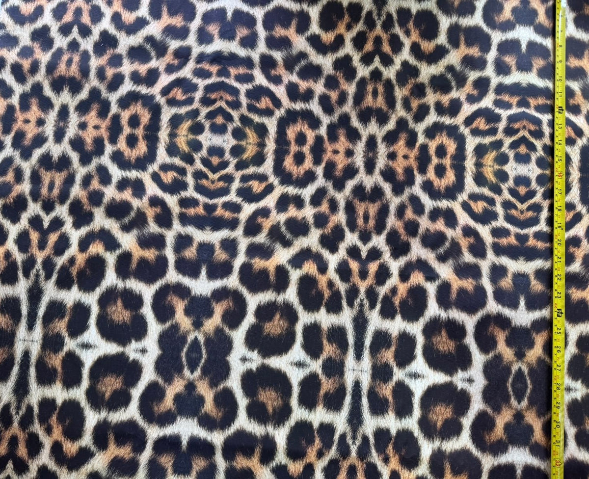 Leopard print upholstery fabric with brown and black spots on a beige background.