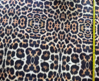 Leopard print upholstery fabric with brown and black spots on a beige background.