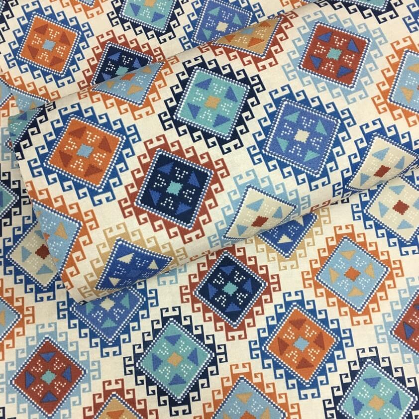 Diamond patterned fabric with geometric square and triangle design in blue, orange, brown, red, navy and white.