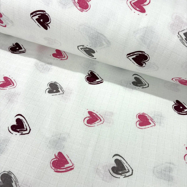 White cotton muslin baby love fabric with brown and pink heart patterns.