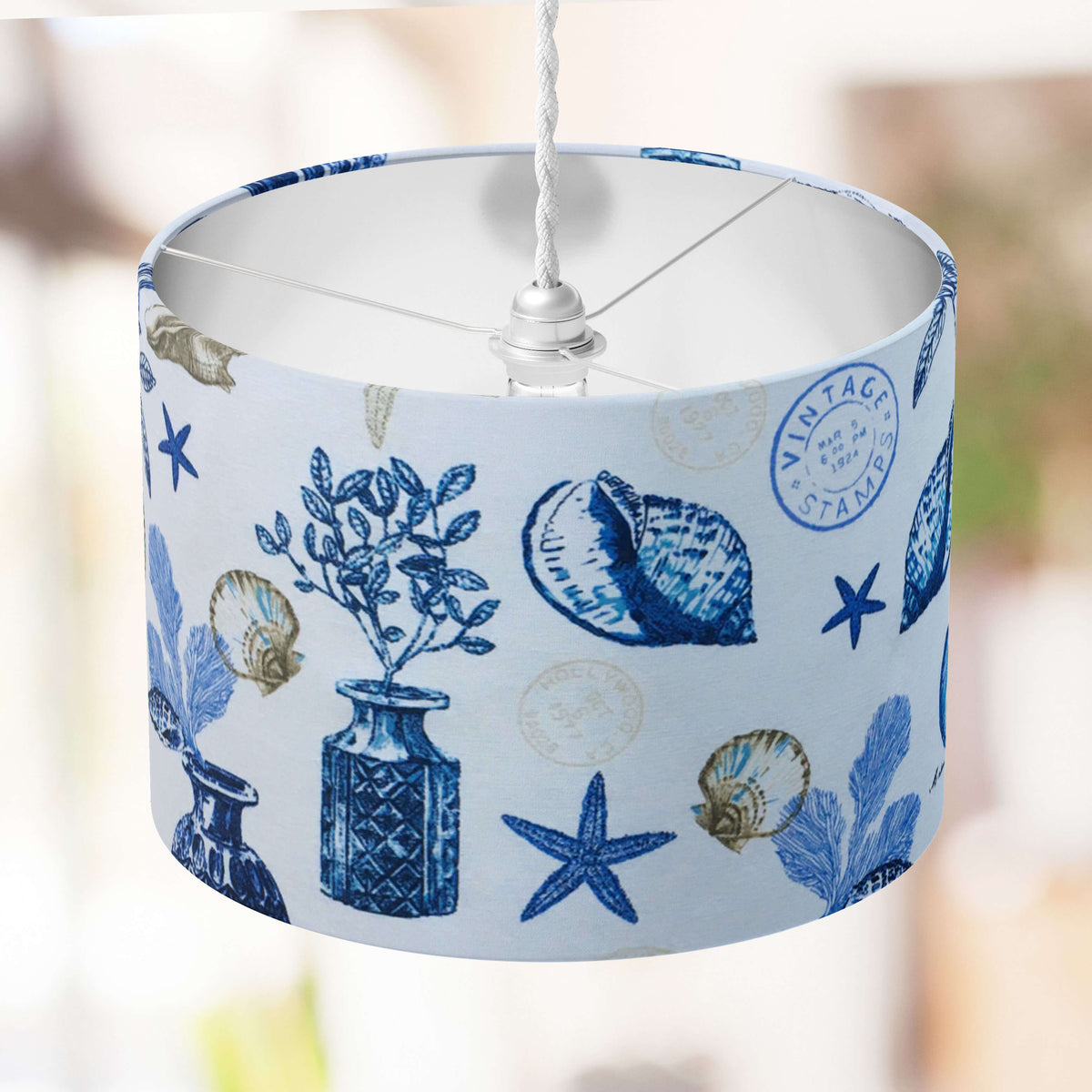 Blue and white ocean seashell lampshade on a blurred background.