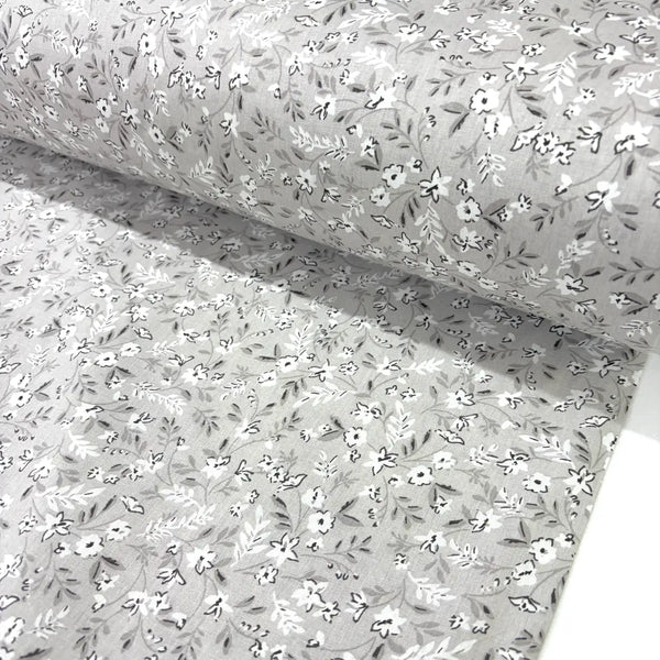 Floral patterned fabric with small white flowers on a beige background.