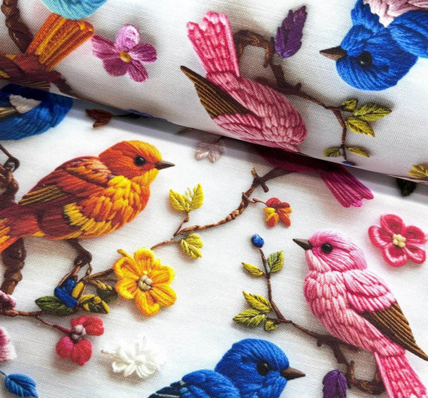 Embroidered upholstery curtain fabric with colorful birds and flowers on a white background.