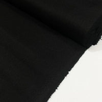 Black cotton duck canvas fabric with a tightly woven texture, suitable for upholstery, curtains, chair covers, bags, and outdoor projects.