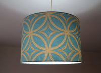 Teal blue ceiling lampshade with gold geometric pattern hanging on a ceiling.