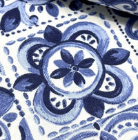 Close-up of blue spanish tile fabric with flowers and geometric patterns.