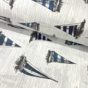 Blue and white nautical fabric featuring hand-drawn sailboats with striped sails on a textured light background.