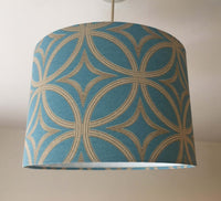 Blue ceiling light shade with gold geometric pattern on a plain background.