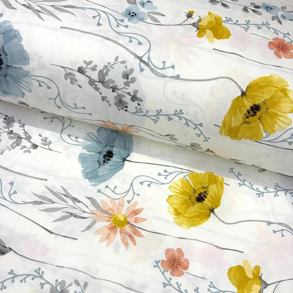 A white cotton poplin fabric with a watercolour floral print featuring yellow poppies, blue flowers, peach blossoms, and gray leaves on delicate stems.