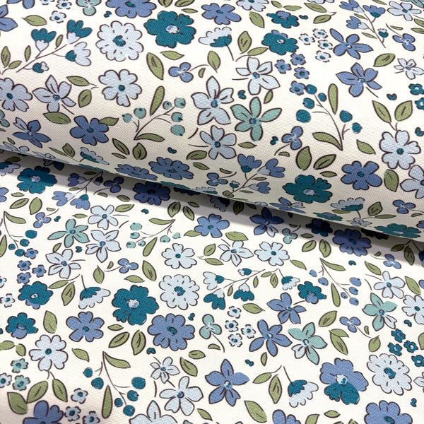 Floral fabric patterned with denim blue flowers and green leaves on a white background.