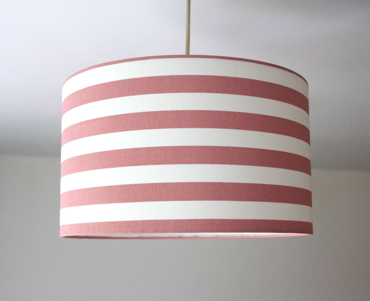 A blush pink and white striped pattern drum ceiling lampshade.