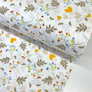 Botanical cotton poplin fabric featuring colourful yellow and cream hearts, blue, orange and green berry sprigs, taupe leaves on a white background.