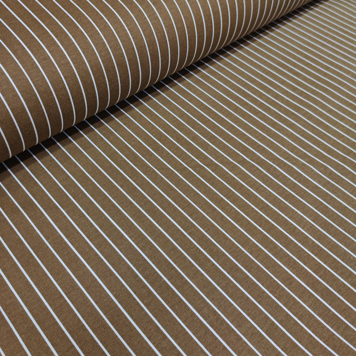 Brown cotton curtain fabric with white stripes, partially rolled up