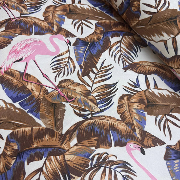 Upholstery fabric with pink flamingo and brown leaves pattern on a white background.