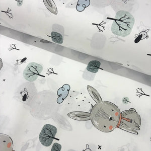 Fabric with bunny and tree pattern on a white background.