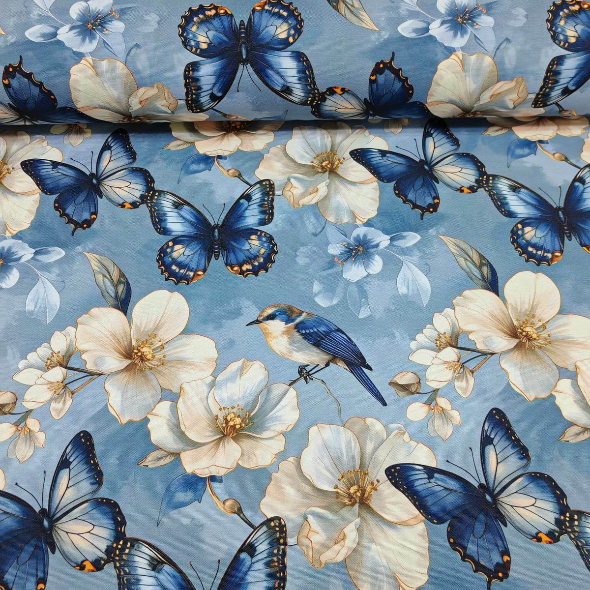 Blue and white upholstery fabric patterned with exotic butterflies, bluebirds and magnolia flowers.