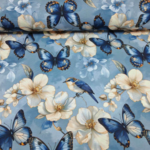 Blue and white upholstery fabric patterned with exotic butterflies, bluebirds and magnolia flowers.