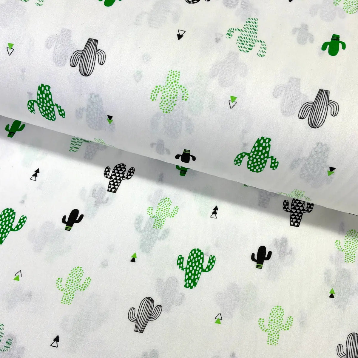 Cotton poplin fabric patterned with green and black cacti on a white background.
