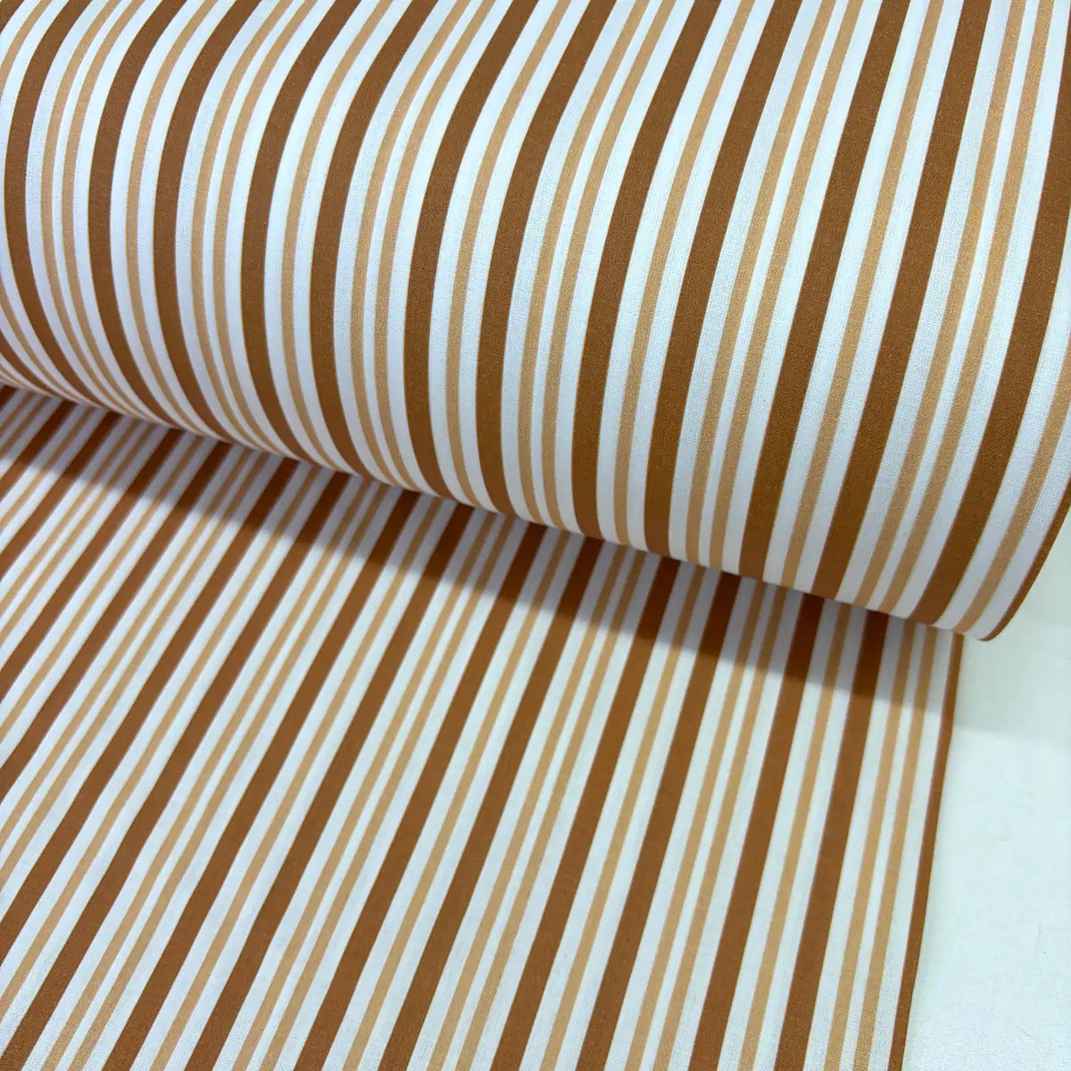 Caramel, brown and white striped cotton poplin fabric with modern multi-width stripes, ideal for dressmaking, quilting, patchwork and craft projects.