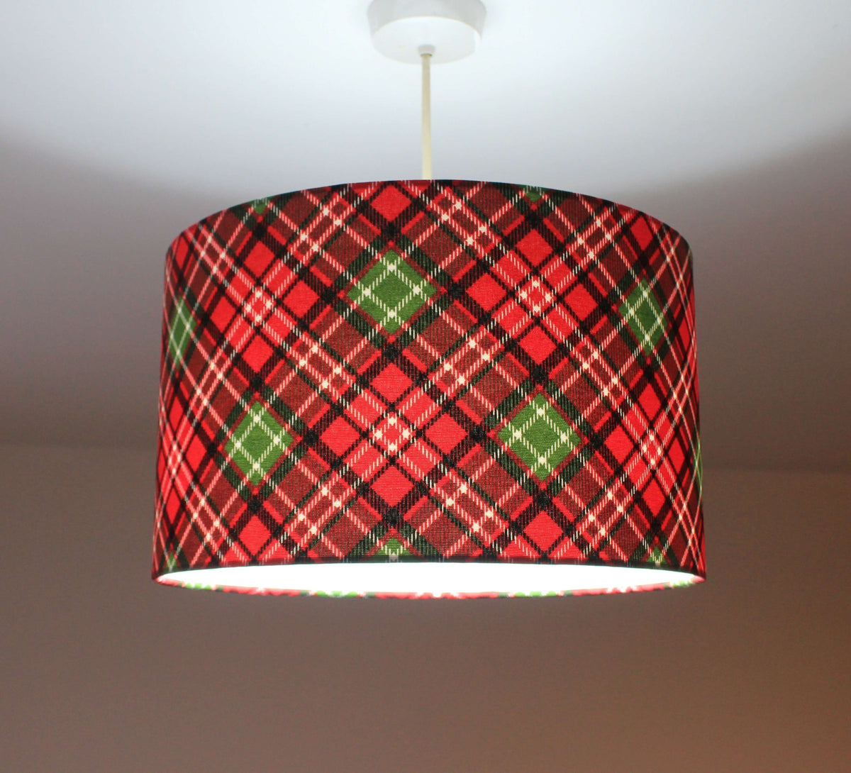 Red and green plaid lampshade on a plain background