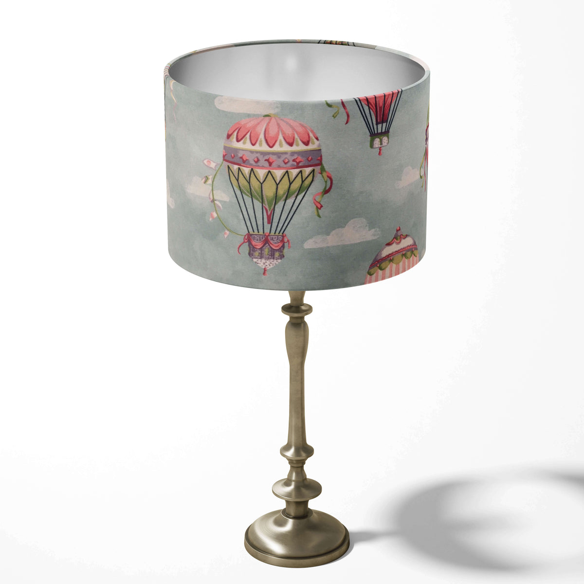 Decorative table lampshade featuring hot air balloons and white clouds on a light blue background.