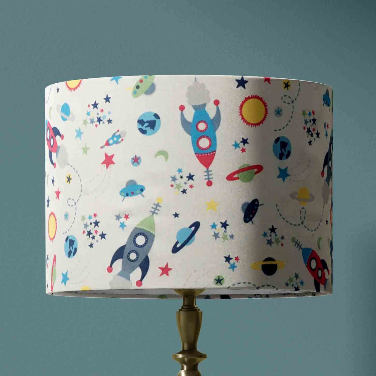 Table lampshade with space-themed design on a teal blue background.