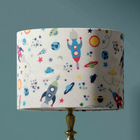 Table lampshade with space-themed design on a teal blue background.