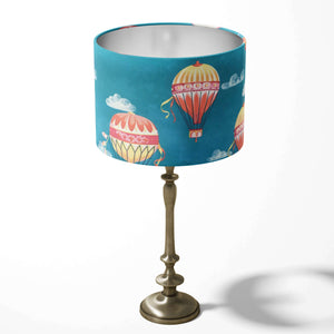 Deep blue table lampshade featuring red and yellow hot air balloons and clouds on a white background.
