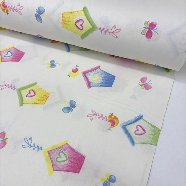 Colorful cotton poplin fabric patterned with birdhouses and butterflies on a white background.