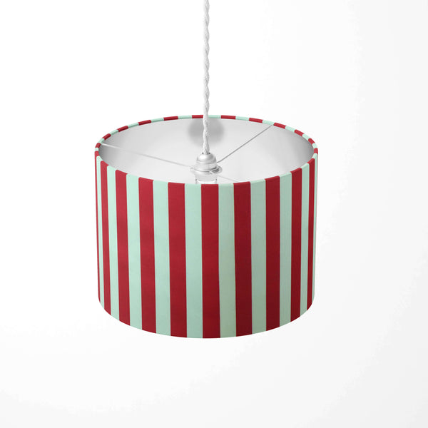 Red circus striped ceiling lampshade with red and white stripes on a white background.