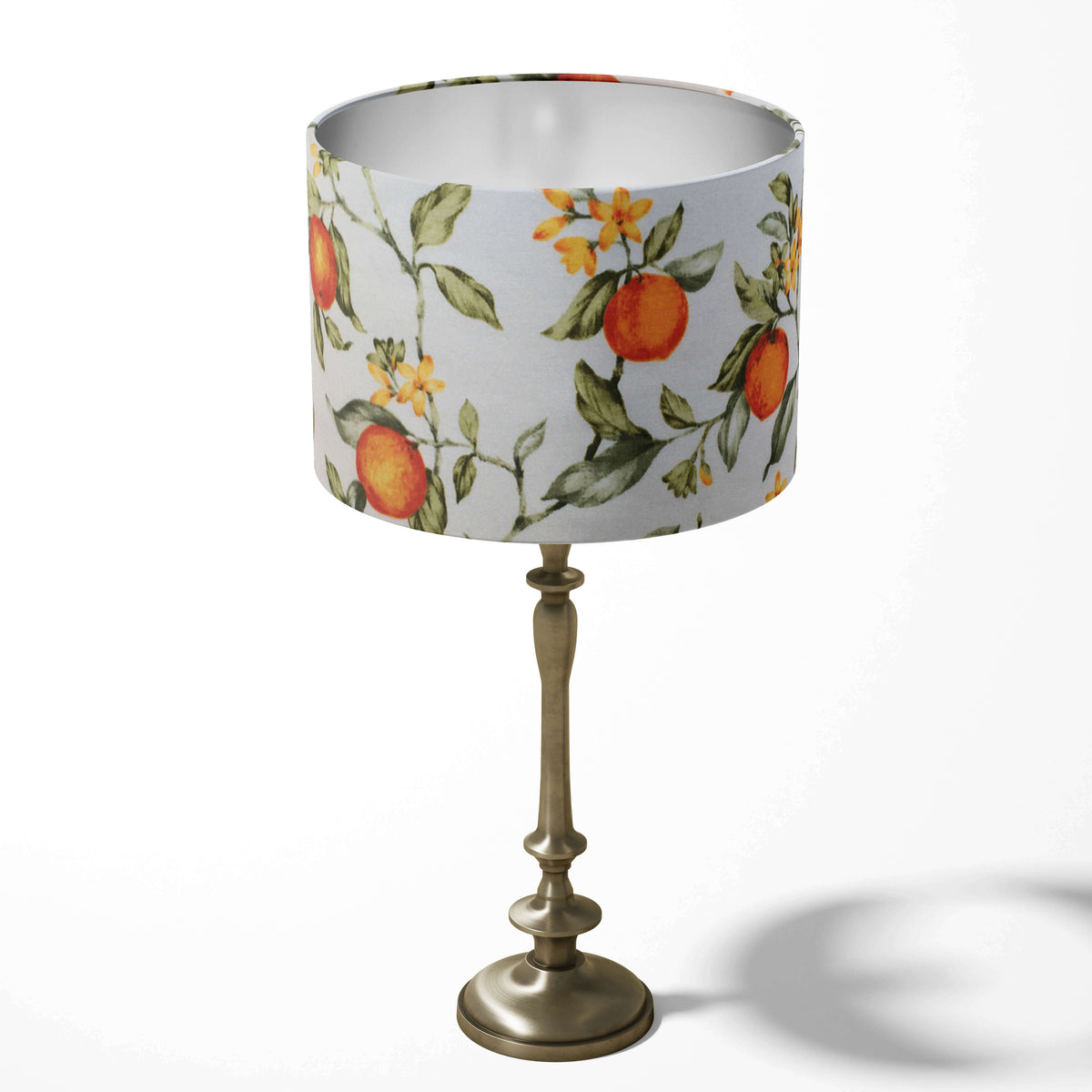 Table drum lampshade with orange citrus and floral pattern on a white background.