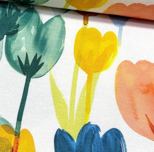 Close-up of colourful floral fabric with tulips on a white background.