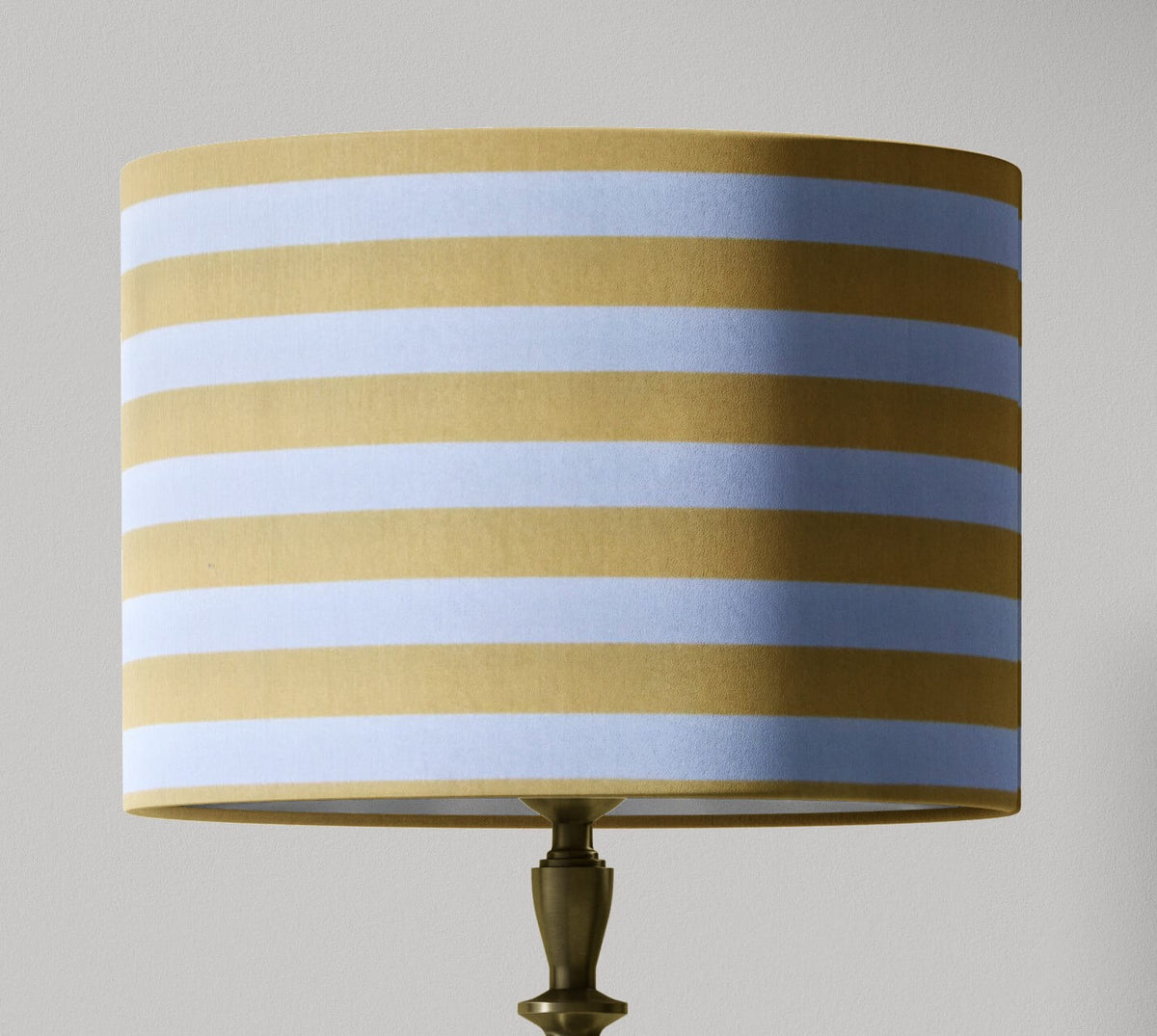 Striped lampshade with light yellow and white horizontal stripes on a gray background.