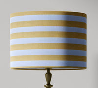 Striped lampshade with light yellow and white horizontal stripes on a gray background.