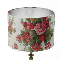 Red flowers and green leaves patterned lampshade on a white background.