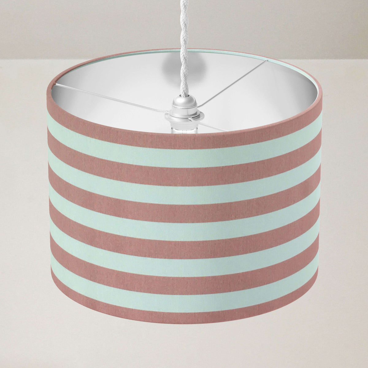 Country cottage striped lampshade with pink and white stripes on a plain background.