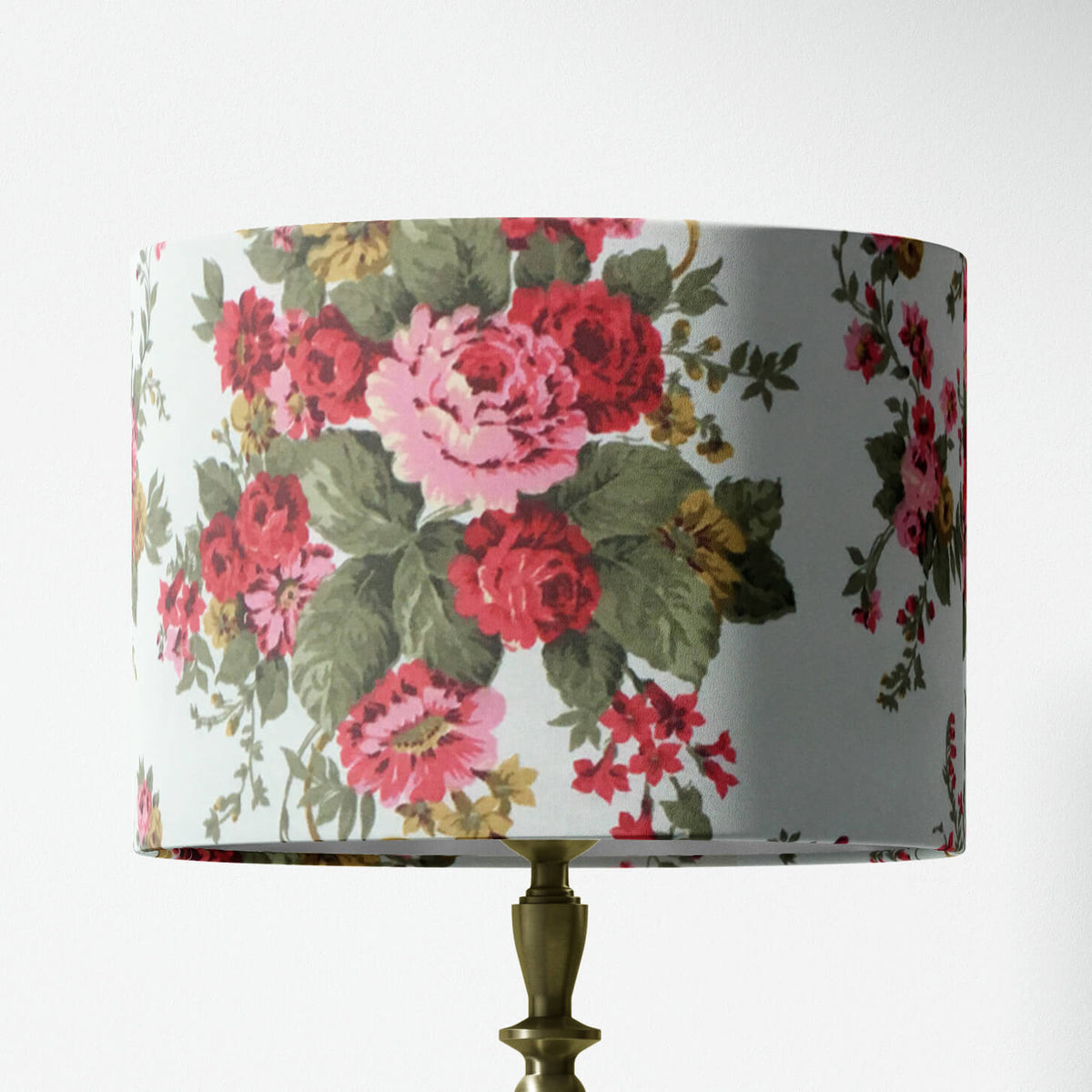 Red pink floral and sage green leaves patterned lampshade on a white background.