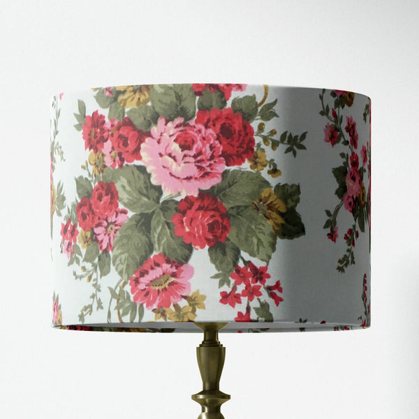 Red pink floral and sage green leaves patterned lampshade on a white background.