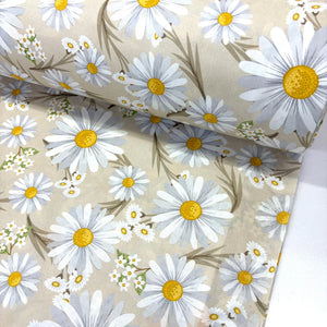 Daisy cotton poplin fabric featuring large white daisies with yellow centres on a beige background, ideal for dressmaking, quilting, patchwork and sewing projects.