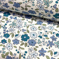 Tiny wildflower fabric patterned with indigo blue flowers on a white background.