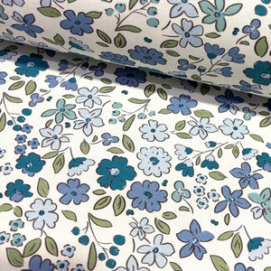 Tiny wildflower fabric patterned with indigo blue flowers on a white background.