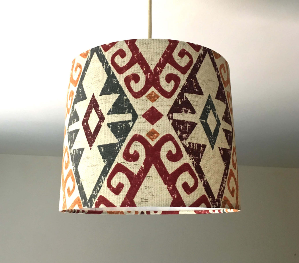 Decorative ceiling lampshade with geometric pattern on a plain background.