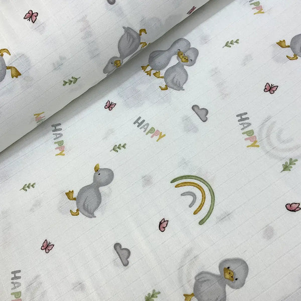 Baby cotton muslin fabric with cartoon duck, rainbow and happy text design on a white background.