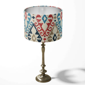 Kilim patterned ethnic table lampshade in red, navy blue and beige on a white background.