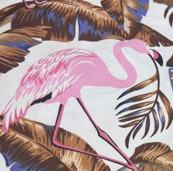 Tropical fabric pattern with pink flamingo and palm leaves.