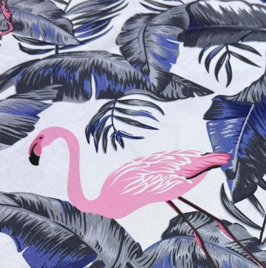 Fabric printed with pink flamingo and tropical leaves pattern on a white background.