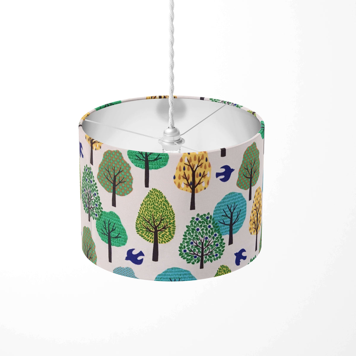 Forest lampshade with green, yellow and blue trees and navy birds on a white background.
