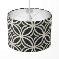 A black and beige geometric patterned lampshade on a white background.