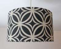 A black and beige geometric patterned ceiling lampshade on a plain background.